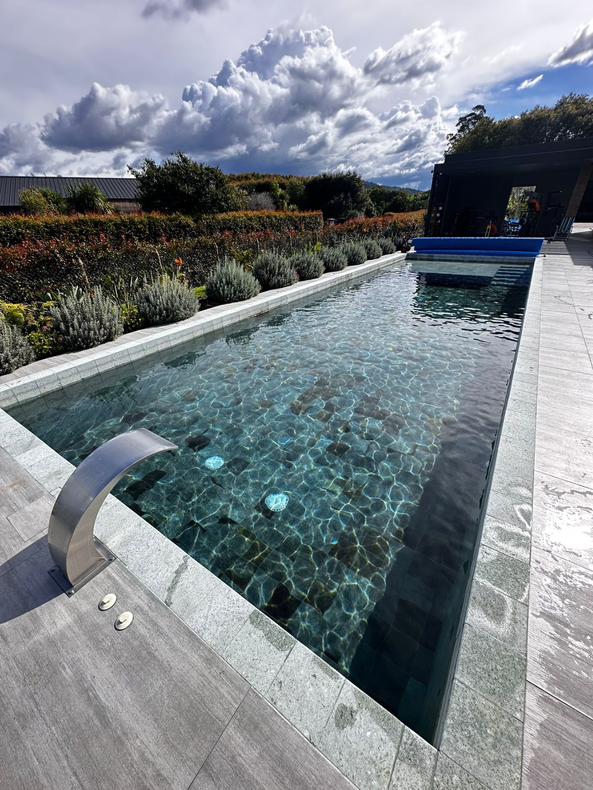 Piscina de diseño con deck en madera y área de descanso — proyecto Homeway Colombia