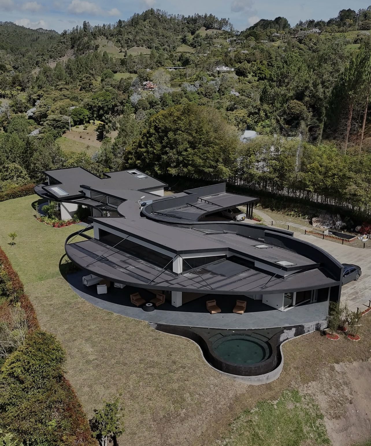 Piscina de diseño contemporáneo con borde infinito y vista a las montañas — Homeway Medellín