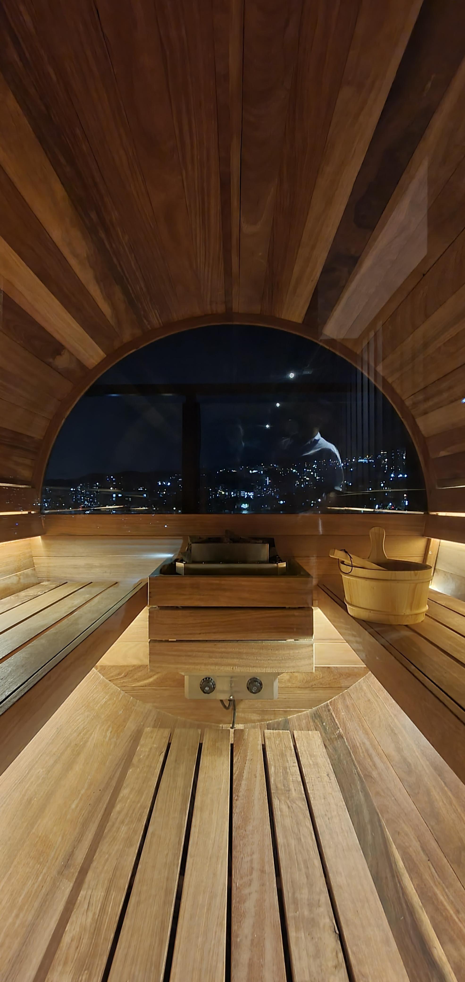 Interior de sauna finlandesa con banco de madera y calentador europeo — proyecto Homeway Colombia